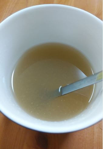 カップの中の生姜湯をスプーンで混ぜている